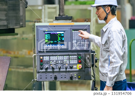 工場の操作盤で機械を操作する作業員 工場の操作盤で機械を操作する作業員 131954706