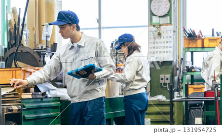 工場で作業するタブレットを持って作業員グループ 131954725