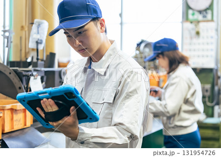 工場で作業するタブレットを持って作業員グループ 131954726
