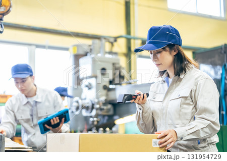 工場でハンディターミナルを使って商品を管理する女性作業員グループ 131954729
