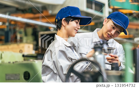 工場で機械を操作する作業員グループ 131954732