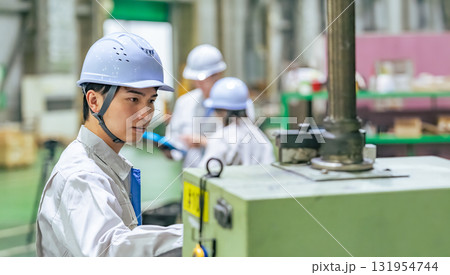 工場で操作盤で機械を操作する男性作業員 131954744