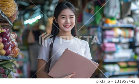 Smiling woman holding tablet at market. Smiling woman holding tablet at market. 131955442