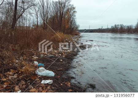 Riverbank covered in garbage and industrial runoff, highlighting the environmental damage caused by pollution Riverbank covered in garbage and industrial runoff, highlighting the environmental damage caused by pollution 131956077