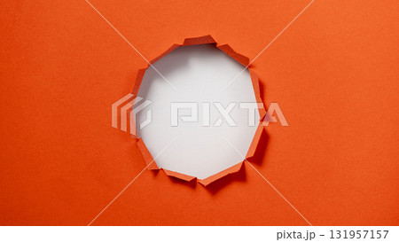 A hole in a piece of orange paper A hole in a piece of orange paper 131957157