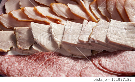 A plate of meat with a variety of meats including ham, sausage, and bacon A plate of meat with a variety of meats including ham, sausage, and bacon 131957183
