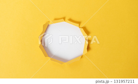 A yellow paper with a hole in the middle 131957211