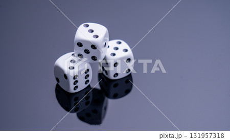 A close-up view of black and white dice on a dark, reflective surface. The dice represent chance, fortune, danger, and decision-making. They are perfect for games, strategic planning, or discussions A close-up view of black and white dice on a dark, reflective surface. The dice represent chance, fortune, danger, and decision-making. They are perfect for games, strategic planning, or discussions 131957318