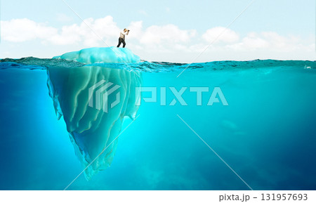 Businessman exploring with binoculars on iceberg 131957693