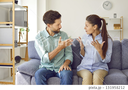 Young couple sitting at home and arguing in the living room. Quarrel and divorce concept. 131958212