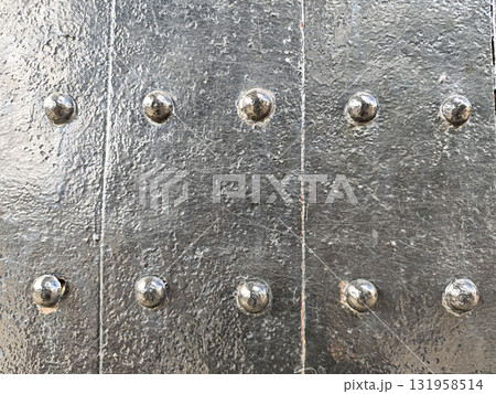 Close up background texture of an old, riveted metal door. strong, antique iron surface with rough, weathered pattern creates an imposing feeling of ancient protection 131958514