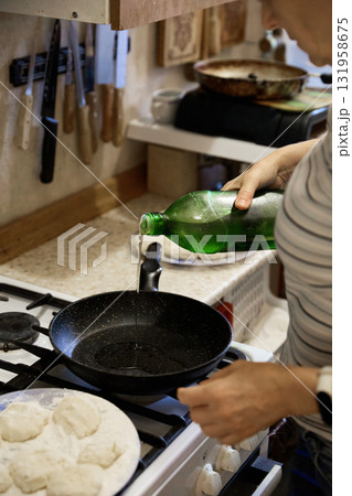 Adding Oil to Frying Pan for Cooking 131958675