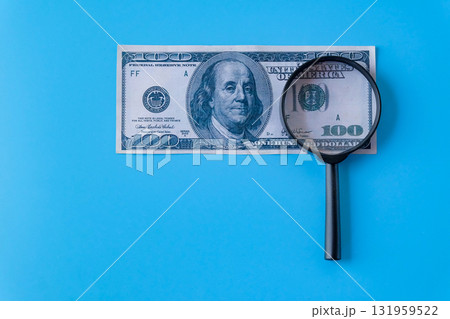 A magnifier glass on a one hundred dollars, Business concept. 131959522