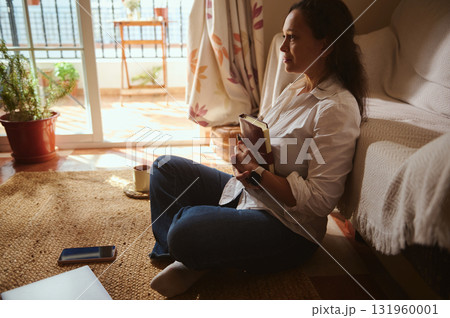 Relaxed Woman Reading Book At Home With Coffee Mug And Phone Relaxed Woman Reading Book At Home With Coffee Mug And Phone 131960001
