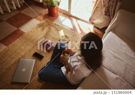 Cozy Home Office Moment With Laptop, Coffee, And Warm Sunlit Window Cozy Home Office Moment With Laptop, Coffee, And Warm Sunlit Window 131960004
