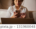 Woman Using Smartphone With Laptop At Home, Casual Tech Communication And Focus On Screen 131960048