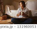 Relaxed Woman With Coffee Mug Working On Laptop In Cozy Living Room 131960053