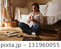 Woman Relaxing At Home With Cup Of Coffee Surrounded By Laptop And Notebook 131960055