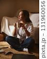 Cozy Morning Moment. Woman Sits On Floor With Coffee Mug, Laptop Nearby 131960056