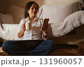 Relaxed Woman At Home Using Phone With Coffee Mug While Sitting On The Floor Cozy Moment 131960057