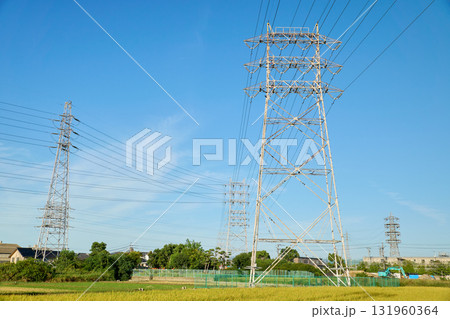 秋の田んぼと青空にそびえる鉄塔 131960364