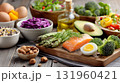 Healthy balanced diet with fresh salmon, vegetables, and nuts on rustic table. 131960421