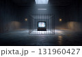 Television in cage with dramatic lighting in dark industrial room. 131960427