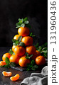Pyramid of fresh tangerines with green mint leaves on dark background. 131960436