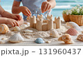 Children building sandcastle at beach with seashells. 131960437