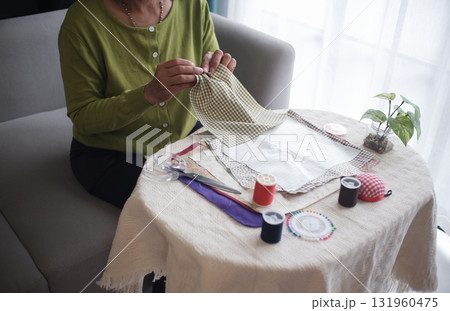 Senior women sewing clothes at home as hobby in her free time, sitting alone, leisure, relax, handcraft concept Senior women sewing clothes at home as hobby in her free time, sitting alone, leisure, relax, handcraft concept 131960475