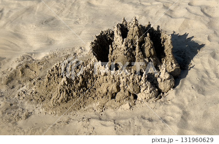 Sand drip castle on beach creating unique sand art structure 131960629