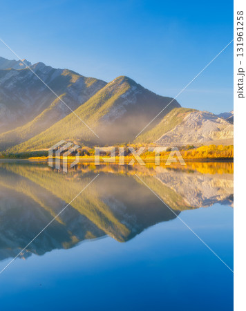 Lake and mountains in a valley at dawn. Reflections on the surface of the lake. Lake and mountains in a valley at dawn. Reflections on the surface of the lake. 131961258
