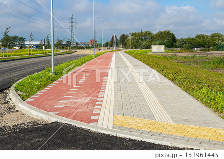 New pedestrian and bicycle walkway with tactile paving and lighting poles in modern urban area New pedestrian and bicycle walkway with tactile paving and lighting poles in modern urban area 131961445