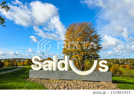 Saldus city landmark sign with large autumn tree and scenic landscape under a blue sky in Latvia 131961455