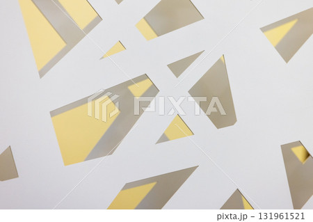 Abstract composition of white cutouts revealing warm yellow light behind 131961521