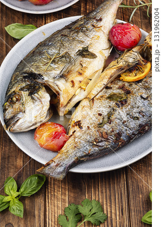 Baked dorado fish with plums served on a plate. Baked dorado fish with plums served on a plate. 131962004