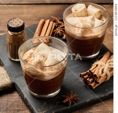 Two glasses of hot chocolate with fluffy marshmallows on a slate board. 131963664