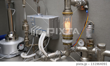 A close-up view of intricate industrial or scientific machinery, with a brightly lit vintage Edison bulb serving as a central element, surrounded by pipes, gauges, and various components 131964091