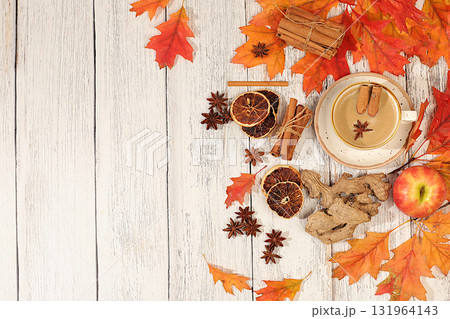 Seasonal abstract composition with hot autumn drink, coffee with foam, and Indian masala chai and fallen leaves, star anise and cinnamon, banner for screen, autumn greeting concept, mockup for menu. 131964143