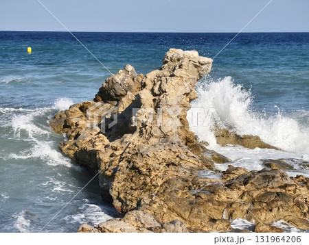 Waves crashing on the rocky shoreline create a beautiful, calming coastal experience 131964206