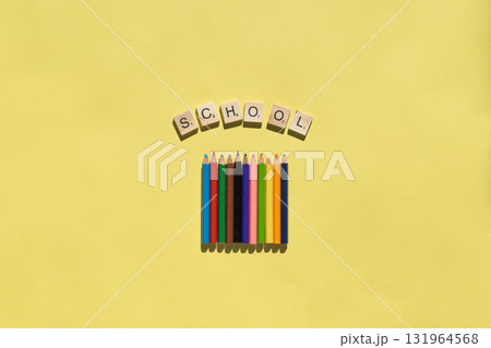 Colorful pencils placed next to the word school on a yellow background. Education and creativity concept for school projects. 131964568