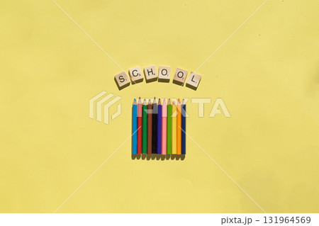 Colorful pencils placed next to the word school on a yellow background. Education and creativity concept for school projects. 131964569