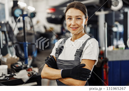 A confident female mechanic in an automotive shop, showcasing her skill and dedication 131965267