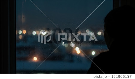 A person's silhouette gazes out a window at night, where the numbers 2026 are etched on the misty glass, with blurred city lights creating a vibrant bokeh effect in the background. A person's silhouette gazes out a window at night, where the numbers 2026 are etched on the misty glass, with blurred city lights creating a vibrant bokeh effect in the background. 131966157