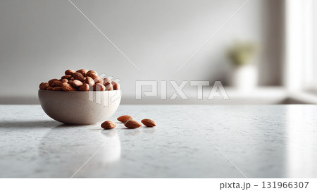 A bowl of almonds on a marble surface, with bright airy background. Represents healthy eating, snack, dieting, nutrition, and mindfulness. Ideal for blogs or recipe websites. 131966307