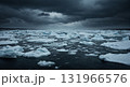 A wide shot of a vast ocean covered with numerous white ice floes and small icebergs under a dramatic, dark, and stormy sky with heavy clouds. 131966576