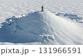 A remote communication tower stands atop a vast snow-covered mountain peak, surrounded by a pristine white winter landscape under bright sunlight, highlighting icy textures and long shadows. 131966591