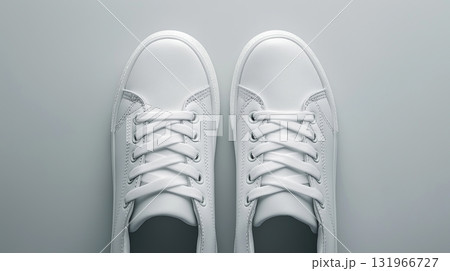 White lace-up sneakers on a light background arranged symmetrically 131966727