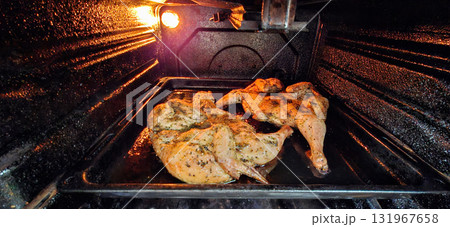 Chicken roasting in oven.  Two tobacco chickens on a baking sheet in the oven. 131967658