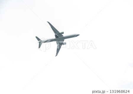 A commercial airplane soars through a bright sky, surrounded by soft clouds, showcasing air travel and freedom in motion. A commercial airplane soars through a bright sky, surrounded by soft clouds, showcasing air travel and freedom in motion. 131968624